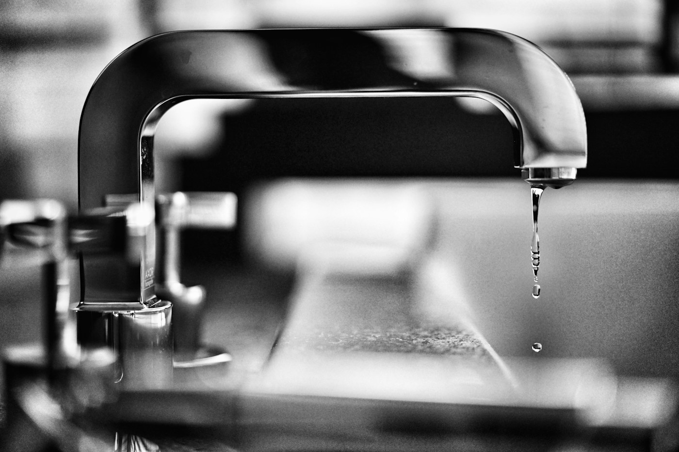 Close-up of a faucet and water droplet